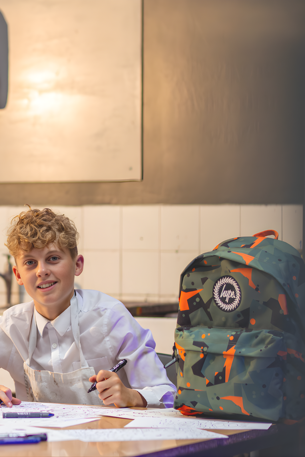 boy student drawing with hype backpack in art class uae